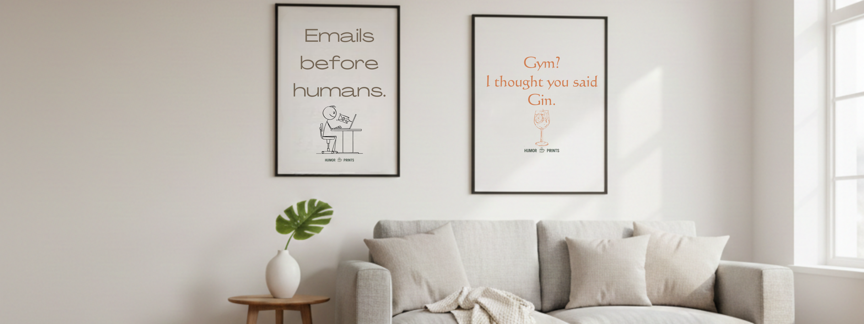 Living room with a gray sofa, small table, and two framed prints on the wall.